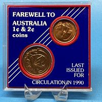 Front view of commemorative coin set in blue background plastic case showing 1 cent and 2 cent coins with label text.