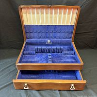 Photo of open Birks wooden cutlery box showing blue plush velvet interior, slots for cutlery, and lower drawer open.