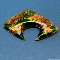 Front view of mid-century copper enamel brooch with green, orange, gold colors
