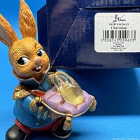 Pendelfin Charming rabbit figurine holding cushion with glass slipper in front of original blue box with label.