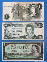 Three banknotes spread out: Bank of England £1 note on top, Bahamas $1 note middle, Canadian $1 Centennial note bottom.