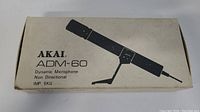 Original box for AKAI ADM-60 microphone, white with black print, showing model and specifications.