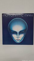 Front cover of the Automatic Man LP album showing a blue alien-like face with 'Automatic Man' title above it.