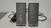 Front view of the two BOSE Companion 2 Series II speakers sitting side by side with power adapter visible.