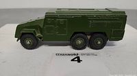 Side view of green Dinky Toys Armoured Command Vehicle model 677 with black tires, showing some minor paint wear.