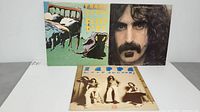 Three Frank Zappa vinyl albums laid out on a white surface.