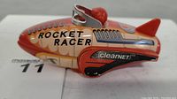 Front and side view of Rocket Racer toy car showing detailed lithograph design and ClearNet branding.