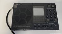 Front view of the Sony ICF-SW7600 portable radio with speaker, digital display, and keypads.
