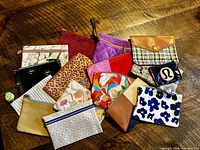 Photo of all the makeup and accessory bags spread on a wooden surface showing various colors and patterns.