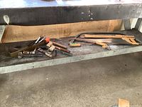 Wide view of the workbench with multiple hand tools including saws, mallets, brace and bits arranged on the surface.