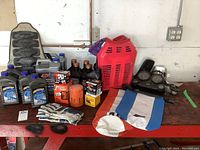 Overall lot image showing oils, filters, safety gear and used parts laid out on a table.