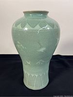 Front view of the green celadon meiping vase showing crane motifs and leaf pattern near the shoulder.