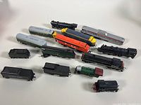 Overhead view of all the locomotives and train cars on a white background, showing various models and colors.