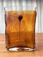Front view of the rectangular amber bubble glass vase showing the brown inclusion and numerous bubbles in the glass.