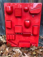 Full front view of red Uten.Silo II wall organizer showing arrangement of modular containers