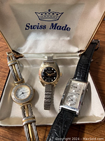 Three watches inside Swiss Made presentation box: left costume watch, center Hamilton Electra, right British Airways watch