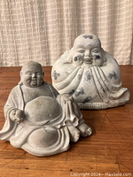 Two cast clay Chinese Buddha statues on wood surface, showing overall condition and size.