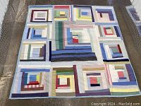 Full view of quilt laid flat showing 5x5 log cabin patchwork blocks