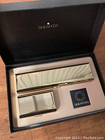 Brass pen case and cartridge case alongside pen in box interior