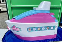 Side view of Barbie Yacht with pink, white, blue colors and floral decal, showing windows with Barbie character illustrations