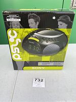 Front view of the Sony ICF CD832 PSBLK CD player and alarm clock in original box with product image and branding.