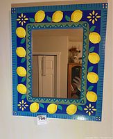Rectangular wall mirror with hand-painted blue wooden frame featuring yellow lemons and decorative patterns.