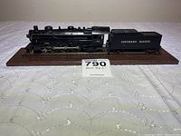 Side angle view of the Southern Pacific 0625 HO scale model steam engine and coal tender mounted on wood base, showing detailed locomotive and tender marked 'Southern Pacific'.