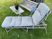 Photo of outdoor chaise lounge with mattress on grassy lawn, showing side profile and cushion details.