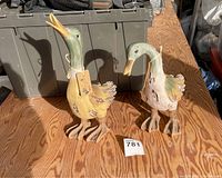 Pair of handpainted duck figurines on wood table, tags visible, green and yellow paint with rustic worn effect.