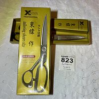 Yellow box with X'sor branding and Japanese text, holding the tailoring shears partially visible inside.
