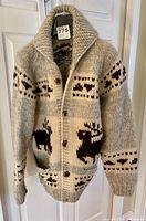Full view of thick knit wool sweater with moose patterns and large shawl collar, showing front and sleeves.