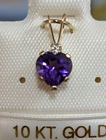 Close-up of pendant showing the purple heart-shaped amethyst and small white topaz set in 10K gold.