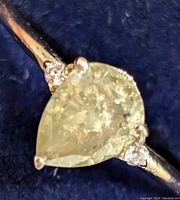 Close-up angled top view of pear-shaped center diamond and adjacent accent stones