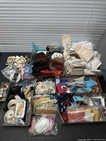 Overview of vintage seamstress lot with multiple trays containing ribbons, laces, trims, and bobbins on a flat surface