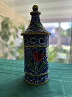 Front view of blue and yellow glazed decorative tower with red floral painting and window cutouts