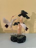 Front and side views of the vintage carved stone heron sculpture showing two herons, stone plants and trees, and the base.