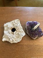 Top view of rough clear quartz candle holder and rough amethyst crystal holder on wood surface, showing natural crystal formations and candle socket holes