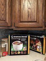 Photo of three boxed items: American Harvest Snackmaster Dehydrator, Food-A-Tray extra dehydrator trays, Spacemaker electric cutter