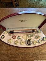 Full interior of the Colonel watch kit case with bezels, bands, watch face and pendant chain visible