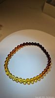 Top view of the stretchy Baltic amber bracelet showing gradient from pale yellow to dark brown beads.