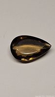 Photo of pear cut natural golden champagne citrine gemstone showing faceted surface and clarity.