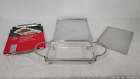Photo shows two metal cooking sheets and a vintage clear glass serving dish in a silver plated holder with handles