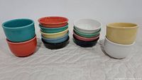 Stacked bowls showing Fiesta Ware dessert bowls and Homer Laughlin small mixing bowls side by side, highlighting size and color variety.