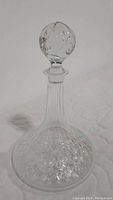 Full view of the clear lead crystal liquor decanter with stopper, showing the cut pattern on the lower part and the overall shape.