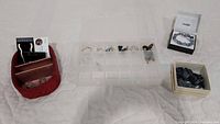 Wide view of multiple jewelry items laid out on fabric, including earrings, rings, and the East 5th bracelet set