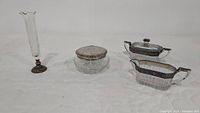 Full view of vintage silver trimmed set: tall bud vase, vanity jar with silver lid, creamer and sugar bowls all with etched crystal and silver details.