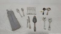 Overall layout of all flatware and serving utensils on white background