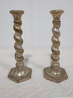 Front view of the two silver spiral candlesticks showing twisted design and hexagonal bases.