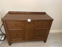 Front view of wood buffet showing drawer and cabinet doors