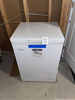 Front view of a white Diplomat chest freezer with control knob and power light on the front lower right. Energy Guide label visible.